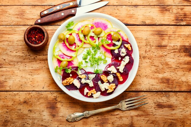 Salada com queijo e legumes frescos em fundo de madeira rústica. Salada fresca de verão.