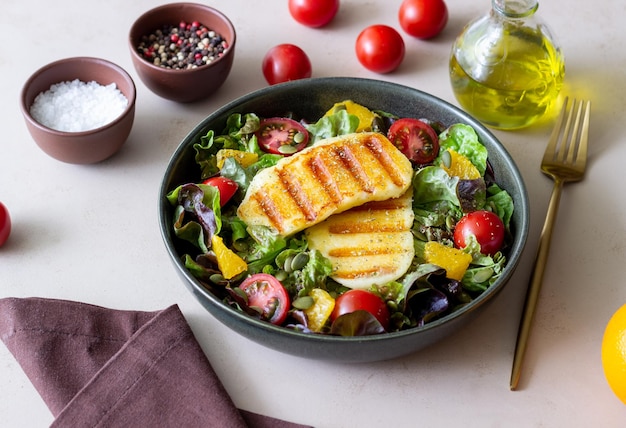 Salada com queijo halloumi grelhado tomate laranja e sementes de abóbora Alimentação saudável Comida vegetariana Dieta cetogênica