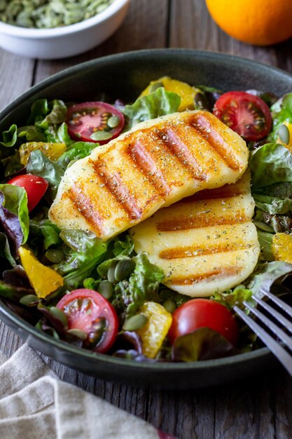 Salada com queijo halloumi grelhado tomate laranja e sementes de abóbora Alimentação saudável Comida vegetariana Dieta cetogênica