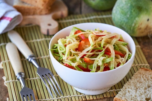 Salada com rabanete verde e pimentão em uma tigela branca