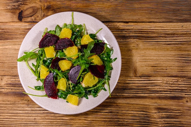 Salada com rúcula, laranja e beterraba em um prato de cerâmica. Vista do topo