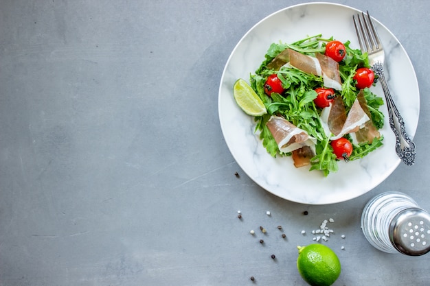 Salada com rúcula, tomate e presunto.