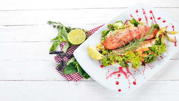 Salada com salmão assado e legumes Em um fundo de madeira Vista superior Copiar espaço