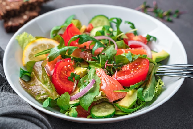 Salada com salmão e abacate em um fundo escuro Comida saudável Vista lateral fechada