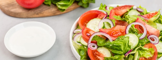 Salada com tomate fresco, pepino, alface, cebola vermelha