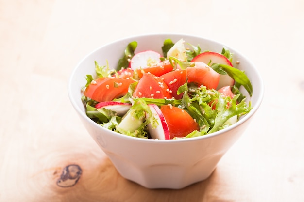 Salada com tomate, pepino, rabanete, rúcula e sementes de gergelim com azeite de oliva