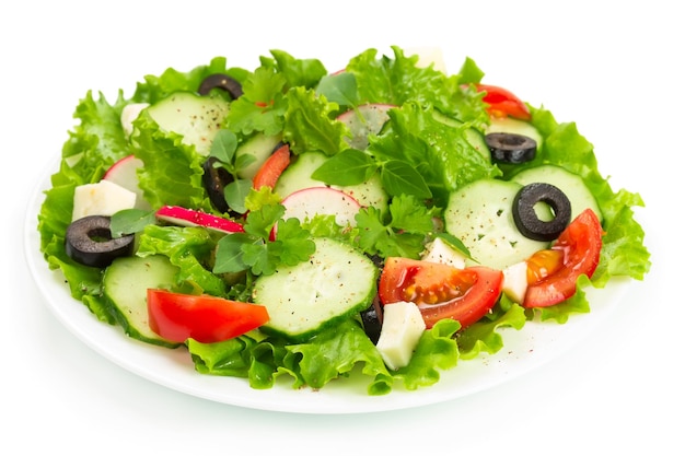 Salada com tomates, pepinos e rabanetes em um prato branco