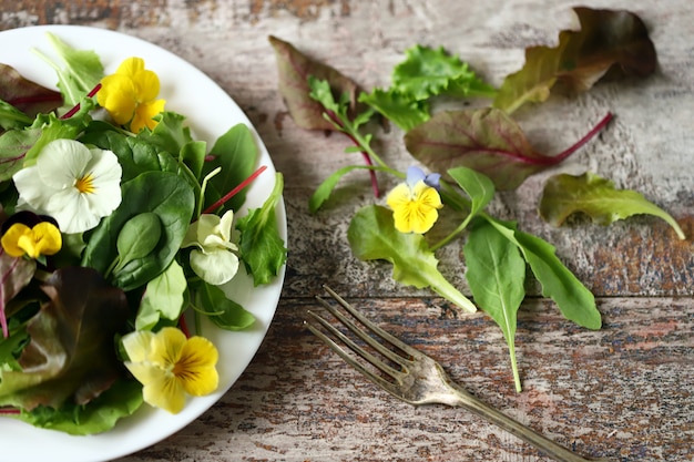 Salada com violetas em um prato branco