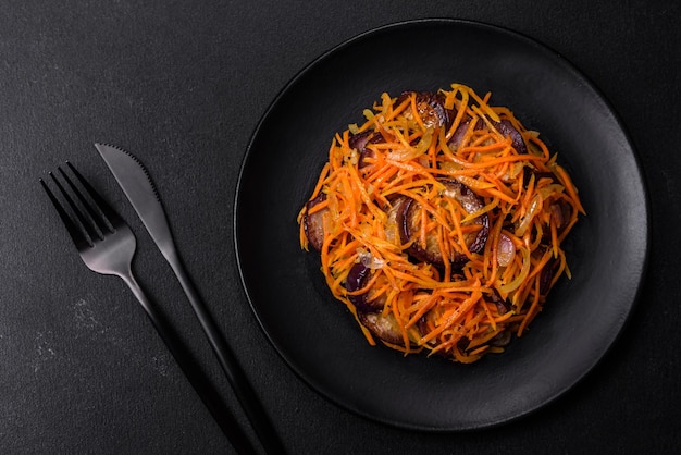 Salada coreana com berinjela cenouras alho especiarias e ervas em um fundo escuro de concreto