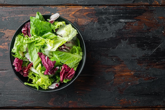 Salada de alface com friso, alface e Radicchio, no fundo da velha mesa de madeira escura