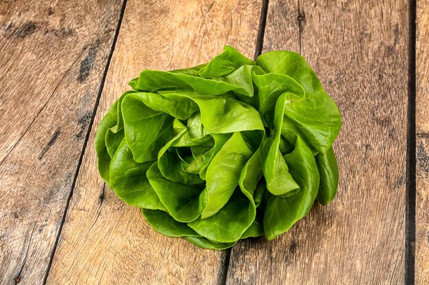 Foto salada de alface de manteiga folhas verdes sobre fundo de madeira