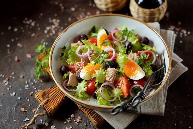 Salada de alface orgânica saudável com atum enlatado, tomate cereja, azeitonas secas ao sol, cebola roxa, ovo e parmesão