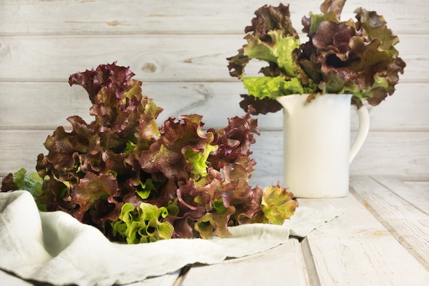 Salada de alface roxa fresca em madeira rústica branca