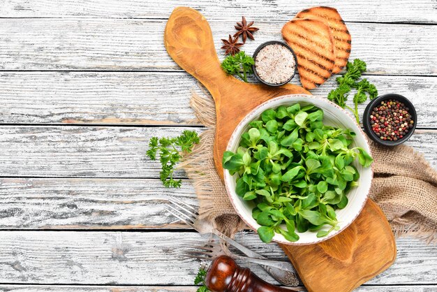 Salada de alface verde fresca em um prato em um fundo de madeira Vista superior Espaço livre para o seu texto Postura plana