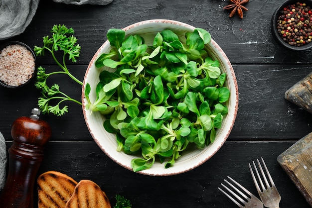 Salada de alface verde fresca em um prato sobre um fundo de madeira vista superior espaço livre para o seu texto postura plana