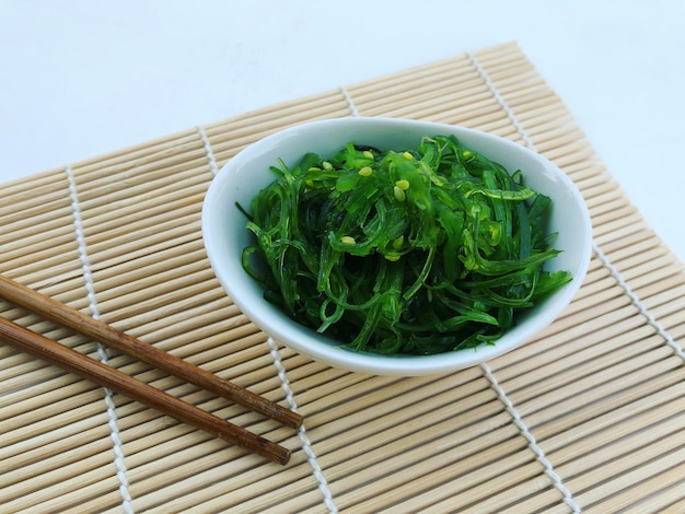 Foto salada de algas wakame com pauzinhos