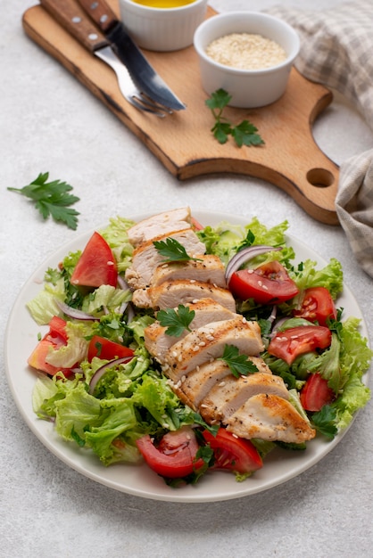 Foto salada de ângulo alto com frango, sementes de gergelim e óleo