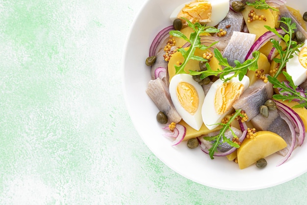 Salada de arenque e batata cozida com alcaparras e cebola roxa Vista de cima