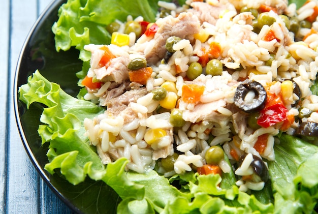 Salada de atum com arroz e legumes no prato preto