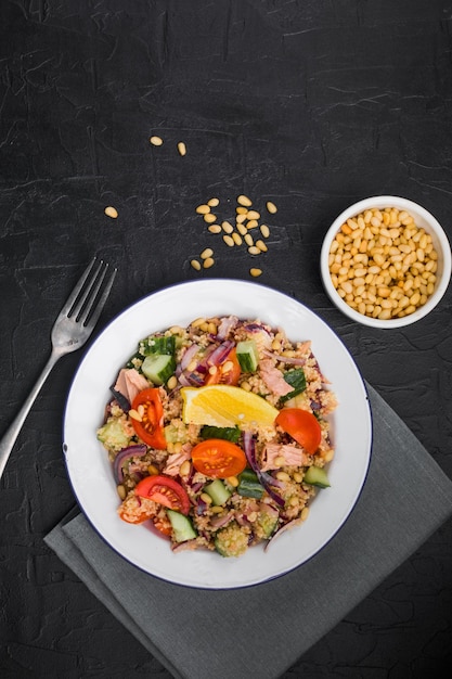 Salada de atum do conceito de dieta alimentar Salada de cuscuz com tomates de atum conservados pepinos e cebolas roxas na mesa Espaço de cópia