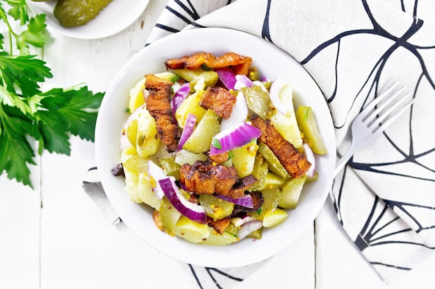 salada de batatas, bacon frito, cebolas roxas e pepinos em conserva no prato