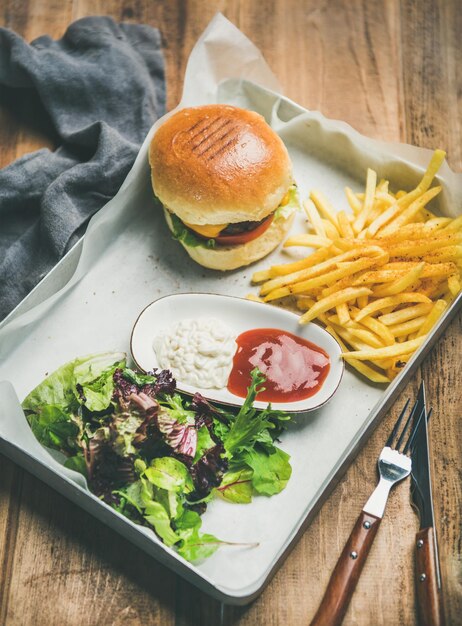 Salada de batatas fritas de hambúrguer de carne e suaces na bandeja