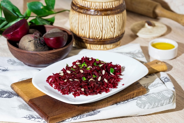 Salada de beterraba com óleo de girassol salsa e sementes de girassol em um prato sobre uma tábua