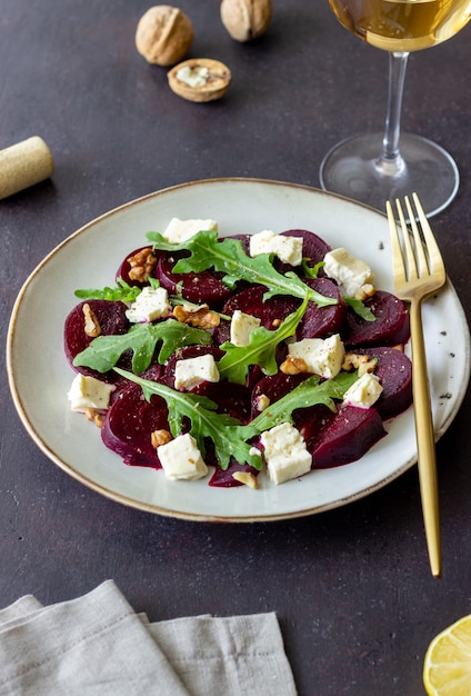 Salada de beterraba com queijo, rúcula, nozes e mel. Alimentação saudável. Comida vegetariana.