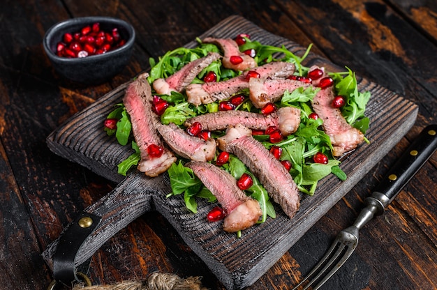 Salada de bife de carne grelhada com rúcula, romã e vegetais verdes