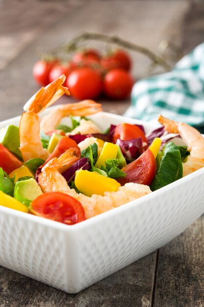 Salada de camarão com manga e abacate na mesa de madeira