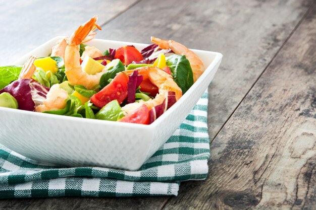 Salada de camarão com manga e abacate na mesa de madeira