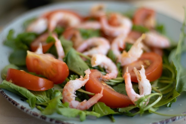 Salada de camarão com tomate alface rúcula abacate pepino e molho de limão na mesa azul