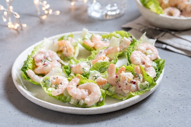 Salada de camarão enrolada em folhas de alface em uma mesa de festas