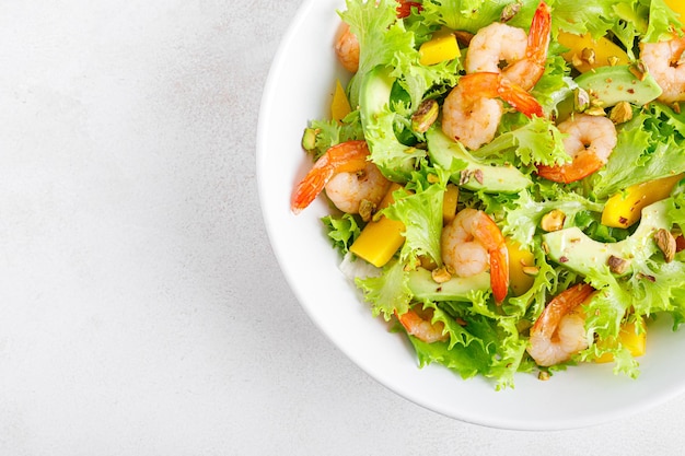 Salada de camarão grelhado com abacate, alface, manga e pistache temperada com limão Comida saudável Dieta cetogênica Vista de cima