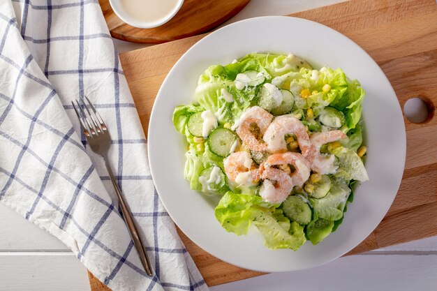 Foto salada de camarão na mesa de madeira branca