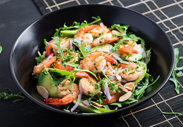 Salada de camarão. Salada de camarão, rúcula, fatia de abacate, cebola roxa e amêndoa. Conceito saudável.