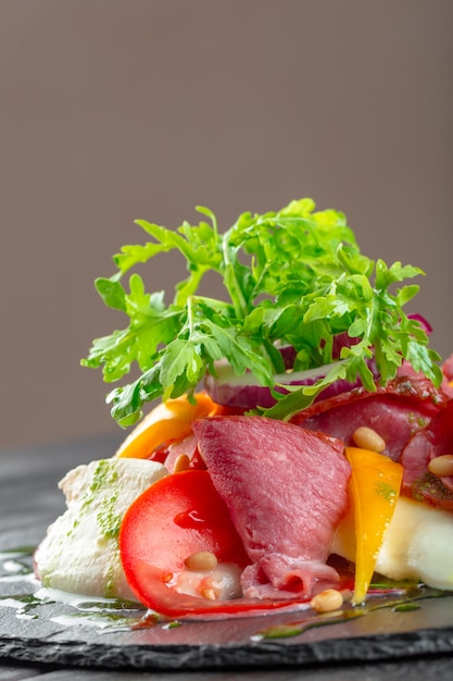 Salada de caqui saborosa fresca com rúcula, presunto de parma, azeite e ervas. outono, inverno comida saudável