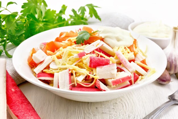 Salada de caranguejo queijo alho e tomate com maionese toalha salsa em um fundo de tábua de madeira