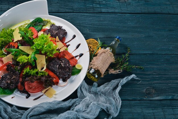 Salada de carne e legumes frescos em uma superfície de madeira vista superior Espaço livre para o seu texto