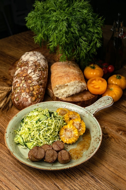 Salada de carne e milho - um farto almoço em uma mesa de madeira