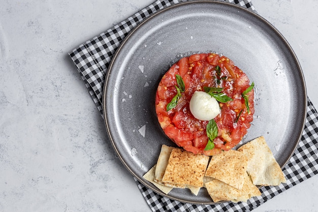 Salada de Carpaccio de Tomate Caseiro com Mozzarella, Azeite e Manjericão com Pão Árabe. Conceito de comida saudável