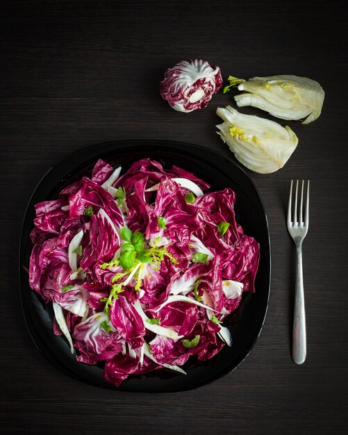 Foto salada de chicória fácil dieta com erva-doce. salada de legumes com endívia, fresca e saudável. a salada vermelha amarga e picante venetian italiana provada do radicchio da chicória. comida vegetariana. comida saudável.