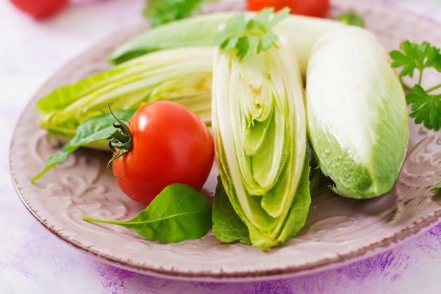 Salada de chicória fresca e saudável (witloof) e tomate em um prato. Menu dietético. Comida saudável.