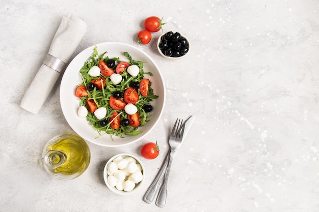 Foto salada de comida diet com tomate rúcula, mussarela e azeite de oliva