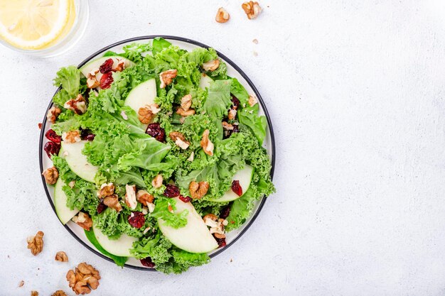 Salada de couve com maçãs verdes secas e nozes Comida vegana saudável vista superior cinza mesa de cozinha fundo