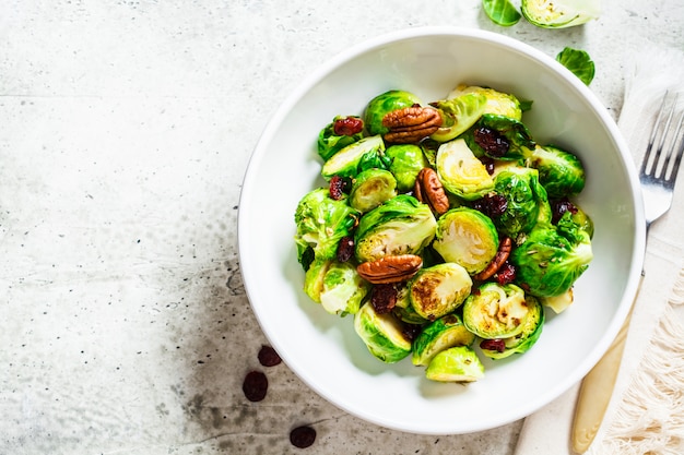 Salada de couve de bruxelas assada com cranberries e nozes em tigela branca