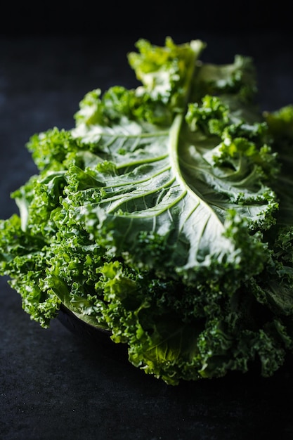 Salada de couve encaracolada fresca sobre fundo rústico escuro