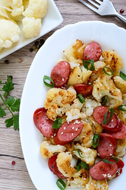 Salada de couve-flor, salsichas grelhadas e cebolinha