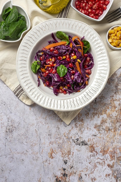 Salada de couve roxa caseira com milho, cenoura, romã e espinafre. Conceito de vegan foof. Comida saudável