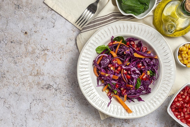 Salada de couve roxa caseira com milho, cenoura, romã e espinafre. Conceito de vegan foof. Comida saudável